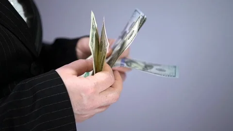 A bundle of money on the table, a lot of dollars in their hands, business people Stock Footage 100372047