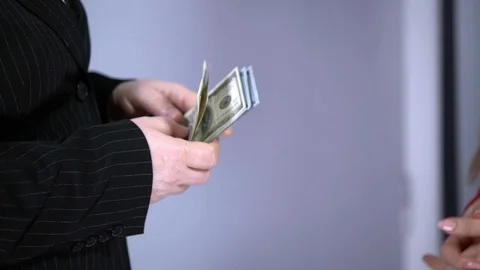 A bundle of money on the table, a lot of dollars in their hands, business people Stock Footage 100372052