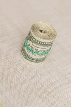 A bundle of money twisted into a bundle and tied with a green rubber band Stock Photos
