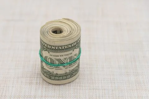 A bundle of money twisted into a bundle and tied with a green rubber band Stock Photos