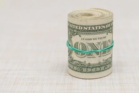 A bundle of money twisted into a bundle and tied with a green rubber band Stock Photos