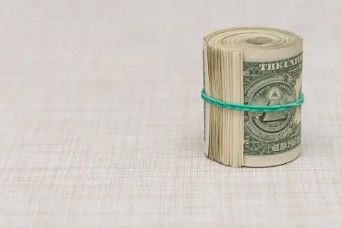 A bundle of money twisted into a bundle and tied with a green rubber band Stock Photos