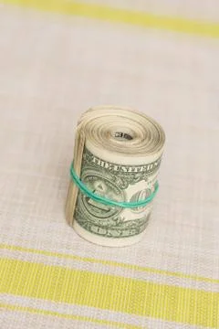 A bundle of money twisted into a bundle and tied with a green rubber band Stock Photos