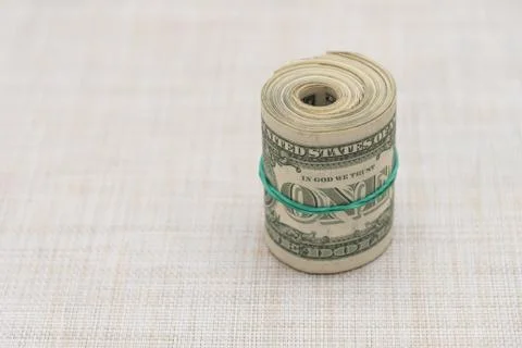 A bundle of money twisted into a bundle and tied with a green rubber band Stock Photos