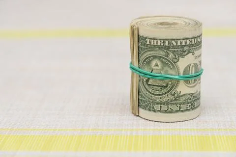 A bundle of money twisted into a bundle and tied with a green rubber band Stock Photos