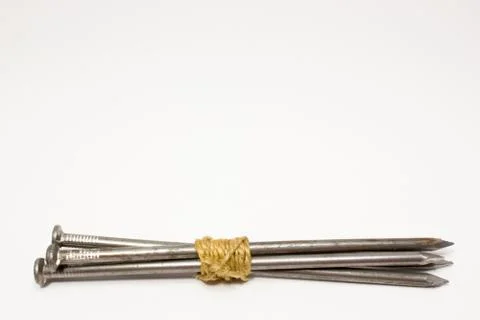The bundle of nails tied up with rope on white background Stock Photos