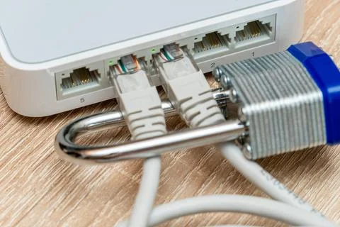 Bundle of network Ethernet wires in router locked with metal padlock Stock Photos