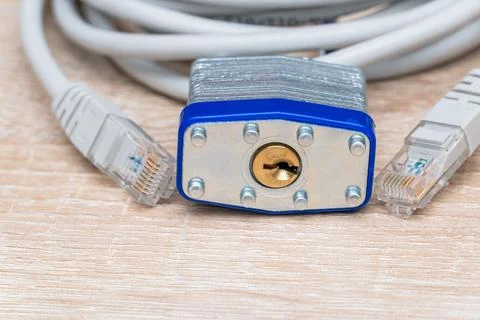 Bundle of network wires with metal padlock on the table Stock Photos