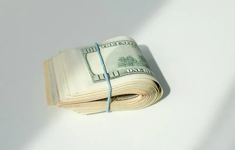 A bundle of one dollar bills is wrapped in a rubber band Stock Photos