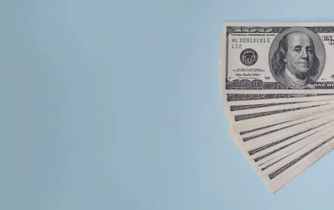 Bundle of one hundred dollar bills on a blue background. Stock Photos