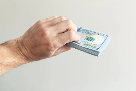 Bundle of One Hundred US Dollars notes in hand Stock Photos