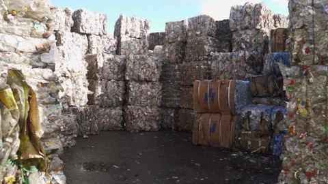 Bundle of pressed plastic bottles prepared for a garbage recycling on waste Stock Footage 163762931
