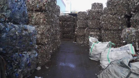 Bundle of pressed plastic bottles prepared for a garbage recycling on waste Stock Footage 164132684