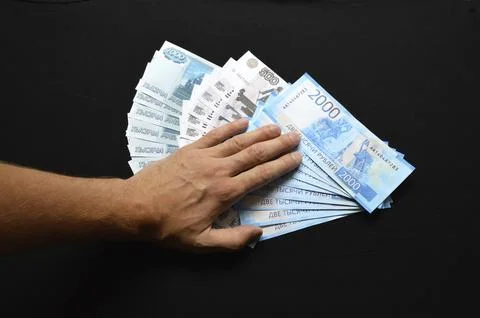 A bundle of Russian rubles is covered with a man's hand Stock Photos