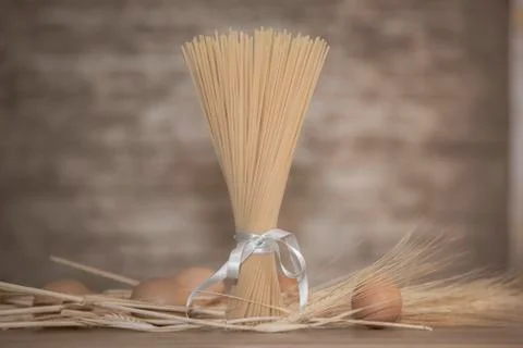 Bundle of spaghetti with wheat and brown eggs Stock Photos