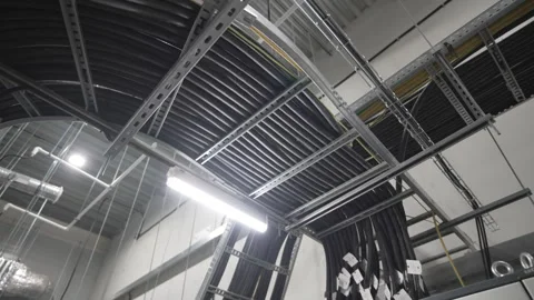 Bundle of thick hoses runs overhead across factory passage Stock-Footage 309760333