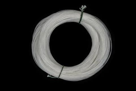 Bundle of white, very old and dusty fishing line on black background surface Stock-Fotos