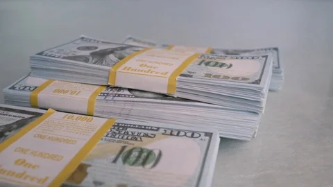 Bundles of Bank money fall down on the white table. Slow motion. Stock Footage