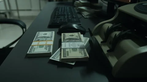 Bundles of Hundred Dollar Bills Lying on Desk with Money Counter Stock-Footage 346712532