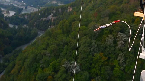 Bungee jump, men facing forward from the bridge with 207m Stock Footage 44763476