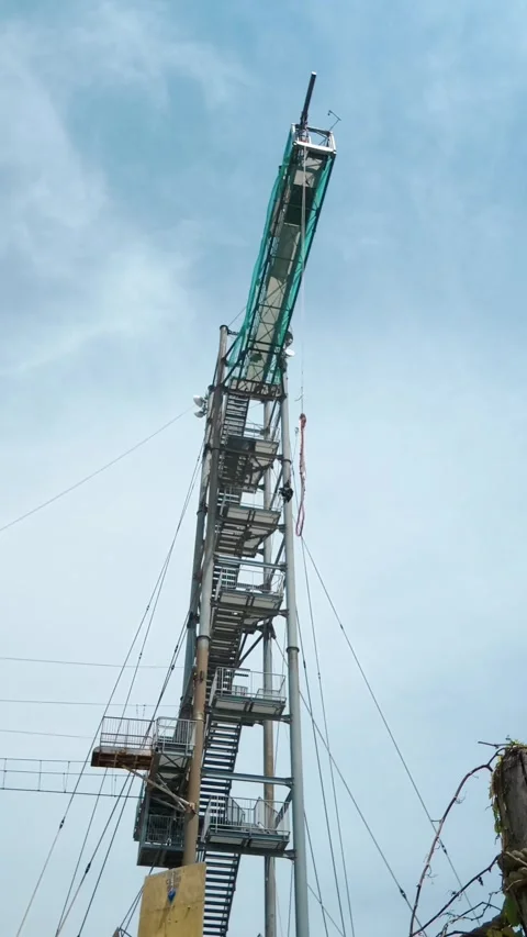 Bungee jump tower preparation in tropical water park against blue sky Stock Footage 337324783
