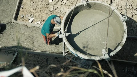 Bunker bucket for concrete and worker. a man pours and levels cement. constructi Stock Footage 163968025