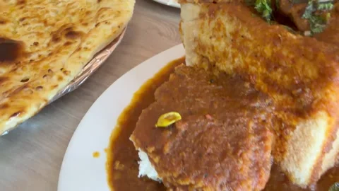 A bunny chow, bread with curry and lamb. A popular indian dish. 動画素材 345260853