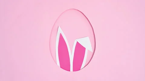Bunny ears appear in Easter egg shape frame on pink background. Stop motion Stock Footage 171359762