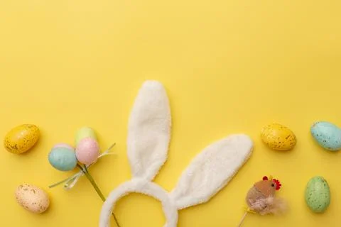 Bunny rabbit ears and Easter decor on yellow background. Easter minimal Stock Photos
