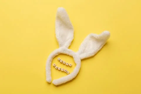 Bunny rabbit ears and Text Happy Easter on yellow background. Easter minimal Stock Photos