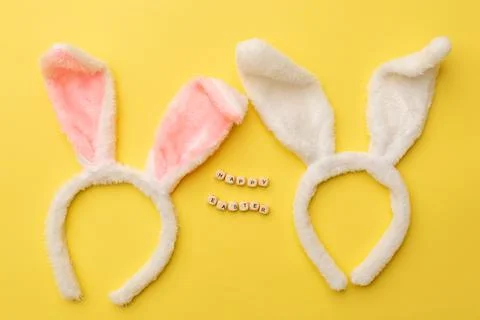 Bunny rabbit ears and Text Happy Easter on yellow background. Easter minimal Stock Photos