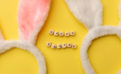 Bunny rabbit ears and Text Happy Easter on yellow background. Easter minimal Stock Photos