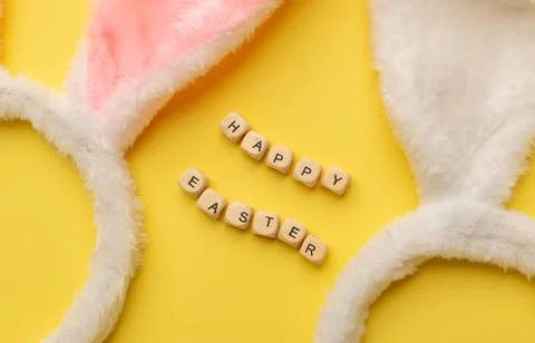 Bunny rabbit ears and Text Happy Easter on yellow background. Easter minimal Stock Photos