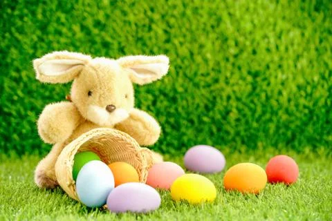 Bunny toy and Easter eggs in basket Stock Photos