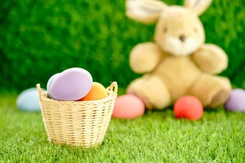 Bunny toy and Easter eggs in basket Stock Photos
