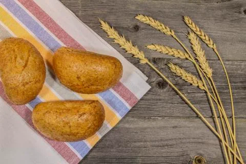 Buns and wheat ears on the table Stock Photos
