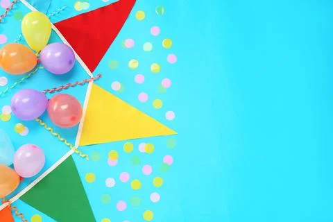 Bunting with colorful triangular flags, balloons, streamers and confetti on l Stock Photos