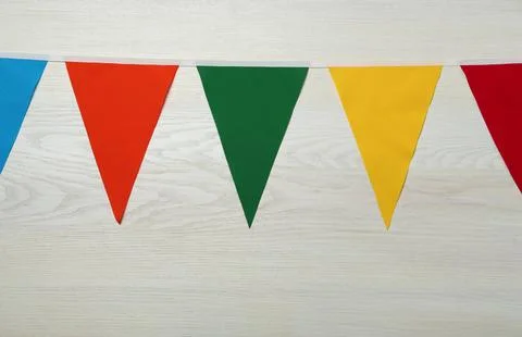 Bunting with colorful triangular flags on white wooden background Stock Photos