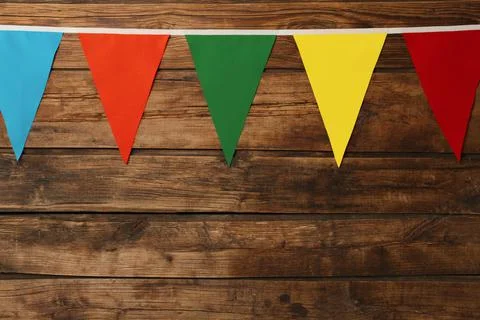 Bunting with colorful triangular flags on wooden background, space for text 스톡 사진
