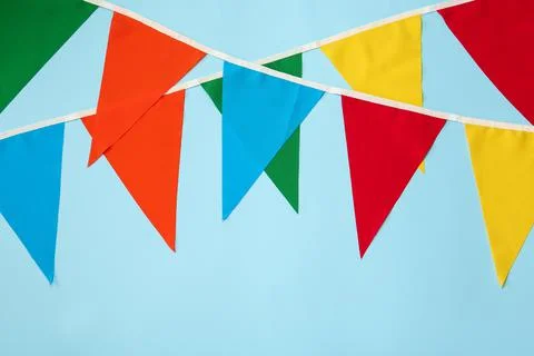 Buntings with colorful triangular flags on light blue background. Festive dec 写真素材