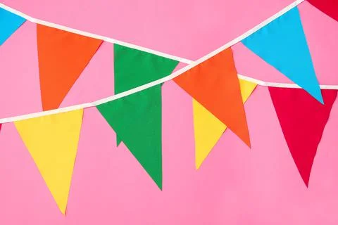 Buntings with colorful triangular flags on pink background. Festive decor 写真素材