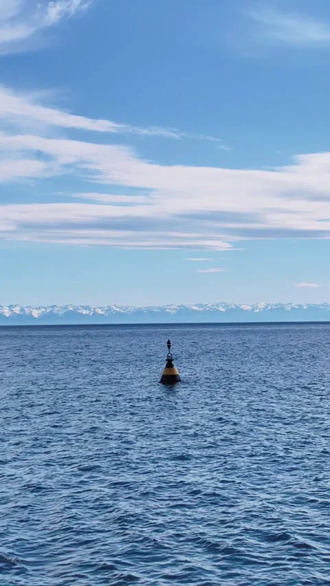 Buoy floating on calm sea with mountain horizon. vertical. Stock-Footage 340700548