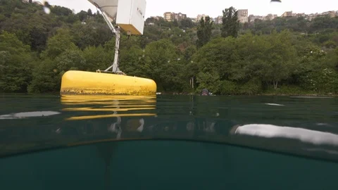 Buoy out of the water in tilt down in the water, diver reaches it, Albano, Italy Stock Footage 107600432