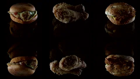 Burger and chicken drumsticks in breaded close-up on a black background lie on Stock Footage 146219860
