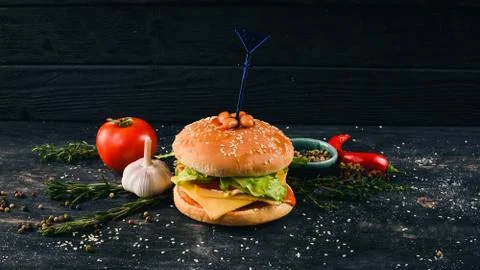 Burger with beans in tomato and lettuce. American Traditional Food. On a blac Stock Photos
