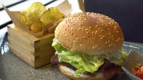 Burger with beef and vegetables rotates. bacon, Hamburger with fries rotated on Video stock 336579576