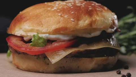 Burger with beef cutlet cheese and tomato on black background Stock Footage 160606943