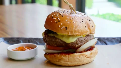 Burger with Beef Cutlet with Melted Cheese, Onion, Tomato Sauce on Black Slate Stock Footage 136810916