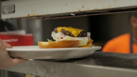 Burger being placed on serving tray Stock Footage 121168170