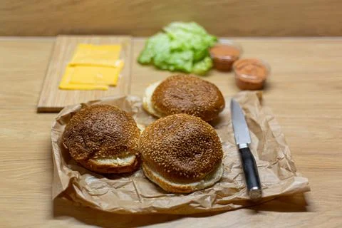 Burger bread, lettuce and cheese on the table. Process of cooking self made b Stock Photos